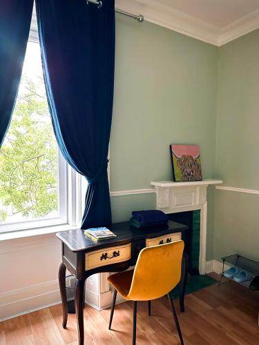 爱丁堡Wee one Flat share accomodation的有窗户的房间里有一张桌子和一把椅子