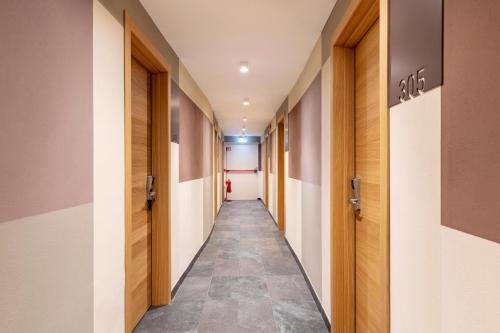 a corridor in a hospital hallway with wooden doors at B&B Hotel Genova City Center in Genova