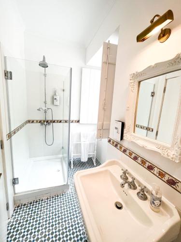 a white bathroom with a shower and a sink at Casa do Vinho Sintra Guest House in Sintra