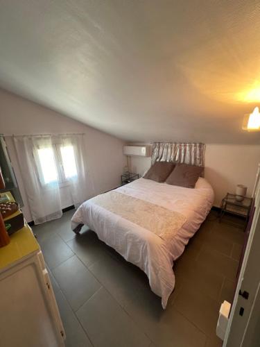 une chambre avec un grand lit dans une pièce dans l'établissement Le Rascassou appartement vue sur la mer, à Narbonne