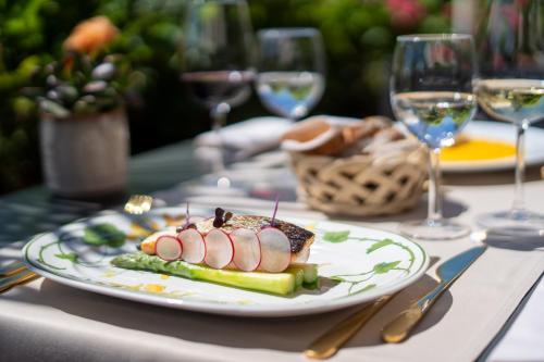 a plate of food on a table with wine glasses at Easy Stay by Hotel La Perla in Ascona