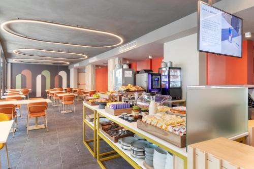 a restaurant with a counter with food on it at B&B Hotel Genova City Center in Genova