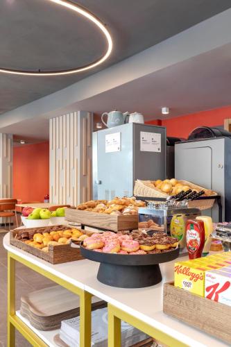 a table with various types of pastries on it at B&B Hotel Genova City Center in Genova