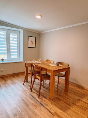 a dining room with a wooden table and chairs at Striķu15 - Dzīvoklis ar terasi in Saldus