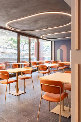 a restaurant with tables and chairs and windows at B&B Hotel Genova City Center in Genova