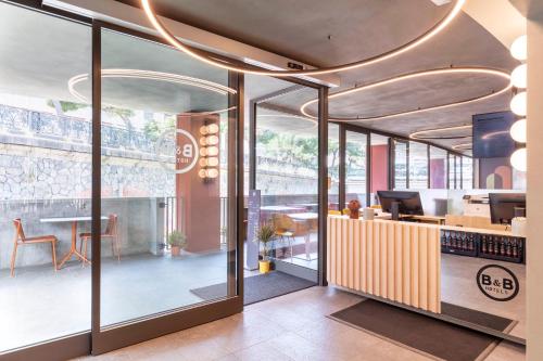 an office with a lobby with a table and chairs at B&B Hotel Genova City Center in Genova