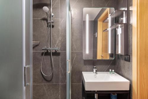 a bathroom with a sink and a shower at B&B Hotel Genova City Center in Genova