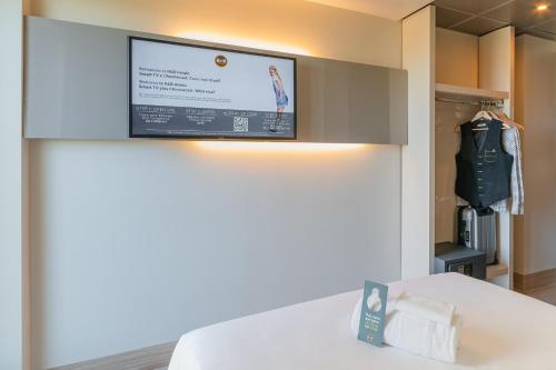 a flat screen tv on a wall in a room at B&B Hotel Firenze City Center in Florence