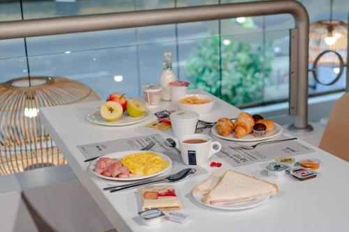 a breakfast table with breakfast foods and coffee on it at B&B Hotel Firenze City Center in Florence