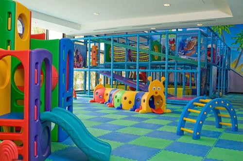 a childrens play room with a playground with colorful equipment at Sunset Room at Pico - Hamilo Coast Pico De Loro in Nasugbu