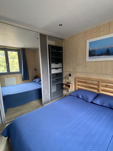 - une chambre avec 2 lits avec des draps bleus dans l'établissement Le Claret, à Autrans