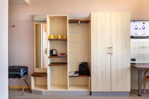 a wooden cabinet in a room with a desk at B&B Hotel Cherasco Langhe in Cherasco