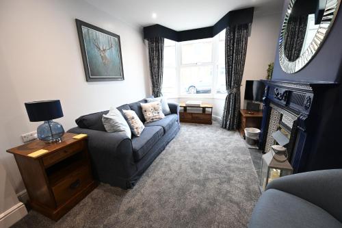a living room with a couch and a fireplace at Wisteria Cottage Town Centre FREE PARKING in Stratford-upon-Avon