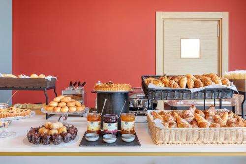 a buffet of pastries and other pastries on a table at B&B Hotel Roma Fiumicino Aeroporto Fiera 2 in Fiumicino