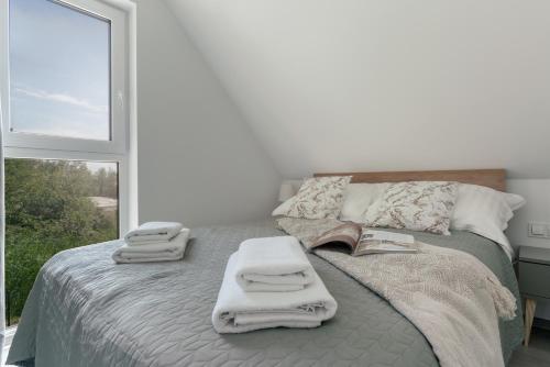 a bedroom with a bed with towels and a window at Morze Ciszy in Dziwnów