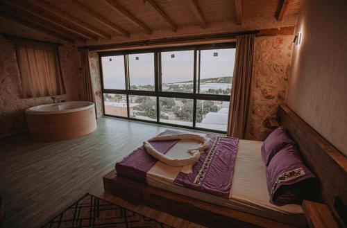 a bedroom with a large window and a bath tub at villa sunrise in Demre