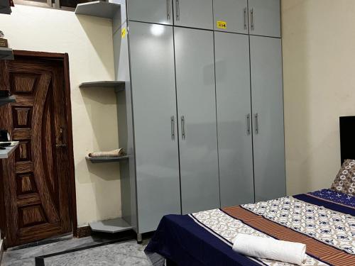 a bedroom with white cabinets and a bed at House for Short Term Renting in Sargodha