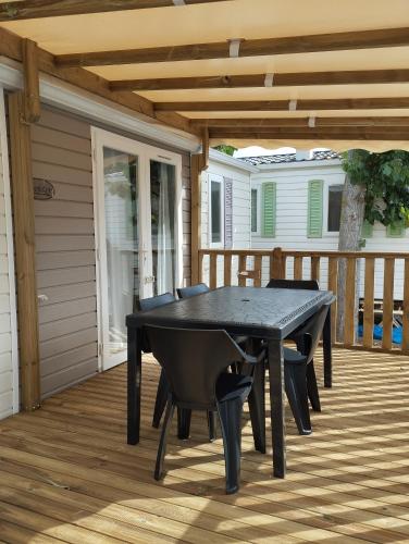 une table de ping-pong noire sur une terrasse dans l'établissement Camping la jasse sables du midi 4 étoiles, à Valras-Plage