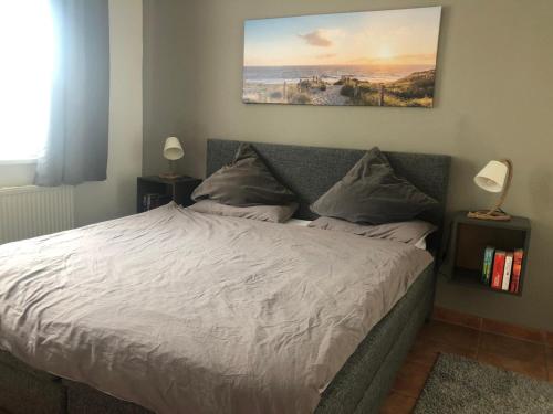 a bed in a bedroom with a painting on the wall at Schöne Wohnung mit Boddenblick in Sagard