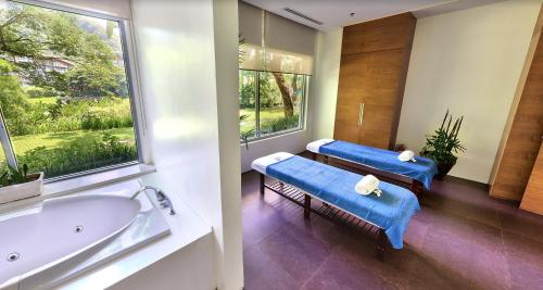 a bathroom with two blue benches and a tub at Sunset Room at Pico - Hamilo Coast Pico De Loro in Nasugbu
