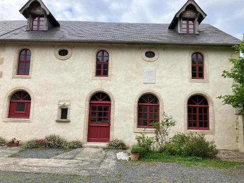 Cette maison ancienne est dotée de portes et de fenêtres rouges. dans l'établissement Manoir de Damigny, à Saint-Martin-des-Entrées