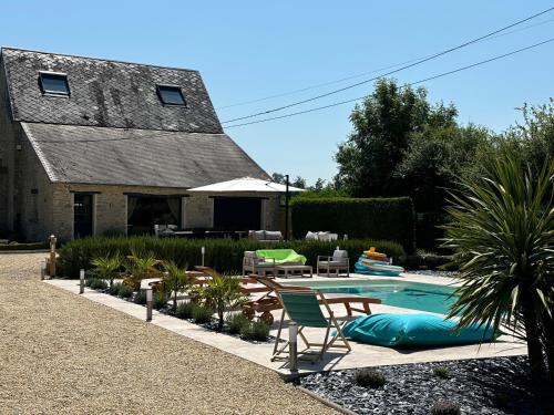 une cour arrière avec une piscine et une maison dans l'établissement La Grange Des Guesdons, à Ellon