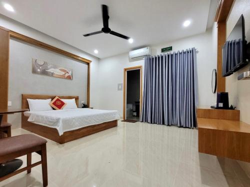a bedroom with a bed and a ceiling fan at Khách Sạn Bảo Hoàng Vũng Tàu in Vung Tau