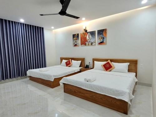 a bedroom with two beds and a ceiling fan at Khách Sạn Bảo Hoàng Vũng Tàu in Vung Tau