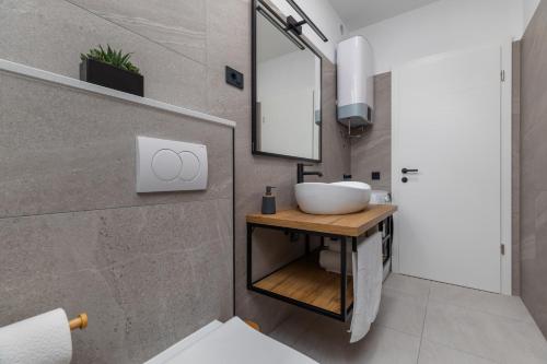 un baño con lavabo y espejo en New apartment Denis, en Vodice