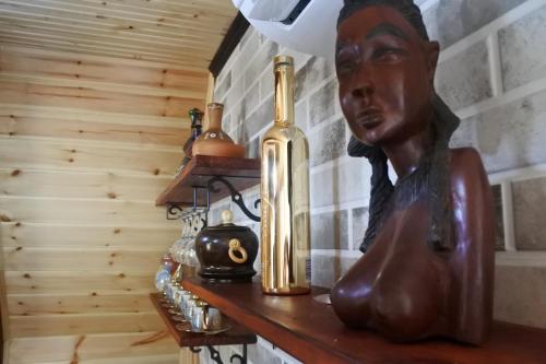 a statue of a woman sitting on a table with a bottle at Ecohouse Machakhela 4 in Machakhela