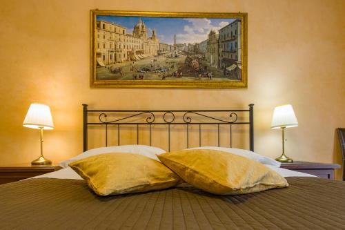 a bed with two pillows and a painting on the wall at Maestoso Locazione Turistica in Rome