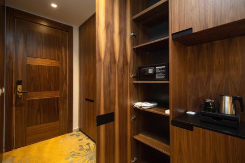 a room with a wooden door and a microwave at Grand Hotel Belushi in Boge