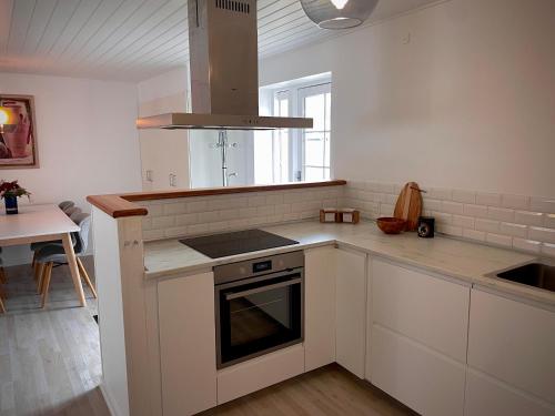 eine Küche mit weißen Schränken und einem Herd mit Backofen in der Unterkunft Charming home in the heart of Hou in Hals