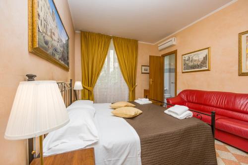 a bedroom with a bed and a red couch at Maestoso Locazione Turistica in Rome
