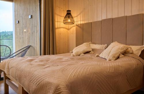 a bedroom with a large bed with a pendant light at Шале Green Land in Bukovel