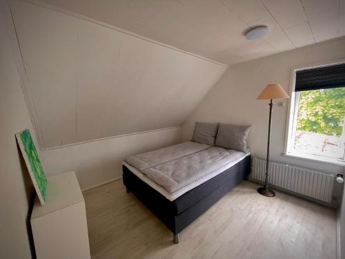 ein kleines Schlafzimmer mit einem Bett und einem Fenster in der Unterkunft Charming home in the heart of Hou in Hals