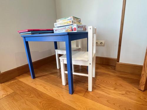 a blue desk with a chair and books on it at Cerca de Santander La Llosa de Muriedas en Urbanización in Camargo