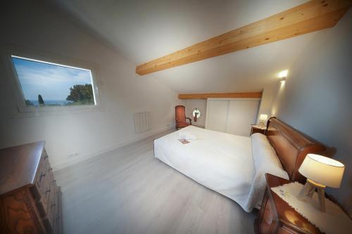 une chambre avec un grand lit blanc et une fenêtre dans l'établissement La tropézienne, à Cassis