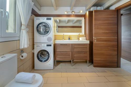 a bathroom with a washing machine and a sink at Kalokairia Residence in Gaios
