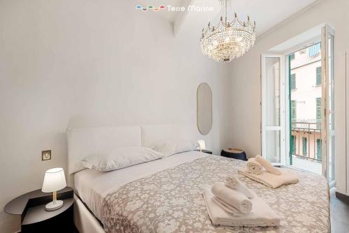 a white bedroom with a bed with towels on it at Luci Danzanti, Terre Marine in Riomaggiore
