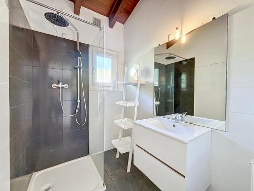 une salle de bain blanche avec une douche et un lavabo dans l'établissement Petite maison familiale - Très proche de la mer - Les Frères de la Loc', à Pietrosella
