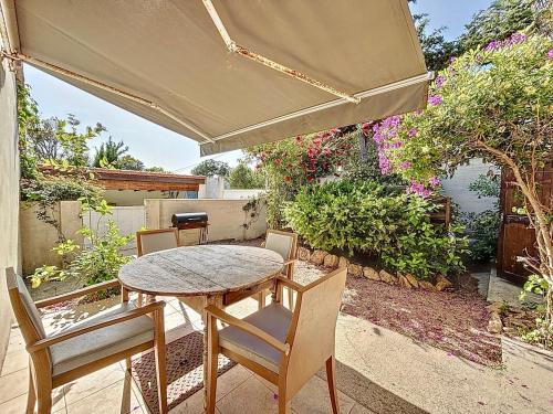 - une table et des chaises sur une terrasse avec un parasol dans l'établissement Petite maison familiale - Très proche de la mer - Les Frères de la Loc', à Pietrosella