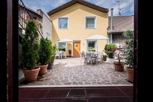 a patio with a table and chairs and potted plants at Am Schloss Guest House in Brunico