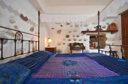 a bedroom with a bed with a blue comforter at Venetiko Apartments in Naxos Chora
