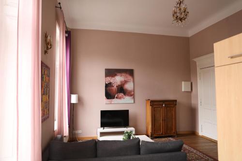 un soggiorno con un divano e una TV di Royal Rose Suite in zentraler Lage a Brema