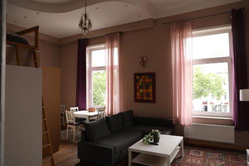 un soggiorno con un divano e due finestre di Royal Rose Suite in zentraler Lage a Brema