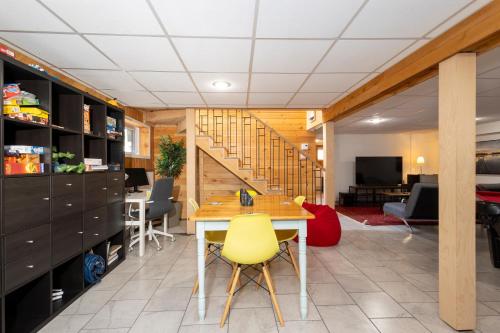 a living room with a table and yellow chairs at Lake House Chalet Laurentians in Nominingue