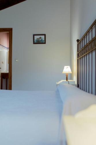 a bedroom with a bed and a lamp and a mirror at El Molino de Bonaco in San Vicente de la Barquera