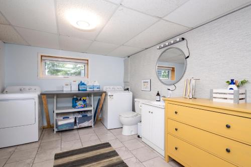 a bathroom with a sink and a washer and dryer at Lake House Chalet Laurentians in Nominingue