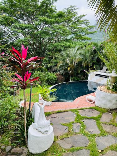a swimming pool with a statue next to a garden at Exclusive Altos del Maria 2 Bedroom Apartment-Private Pool & Mountain Views in Sorá